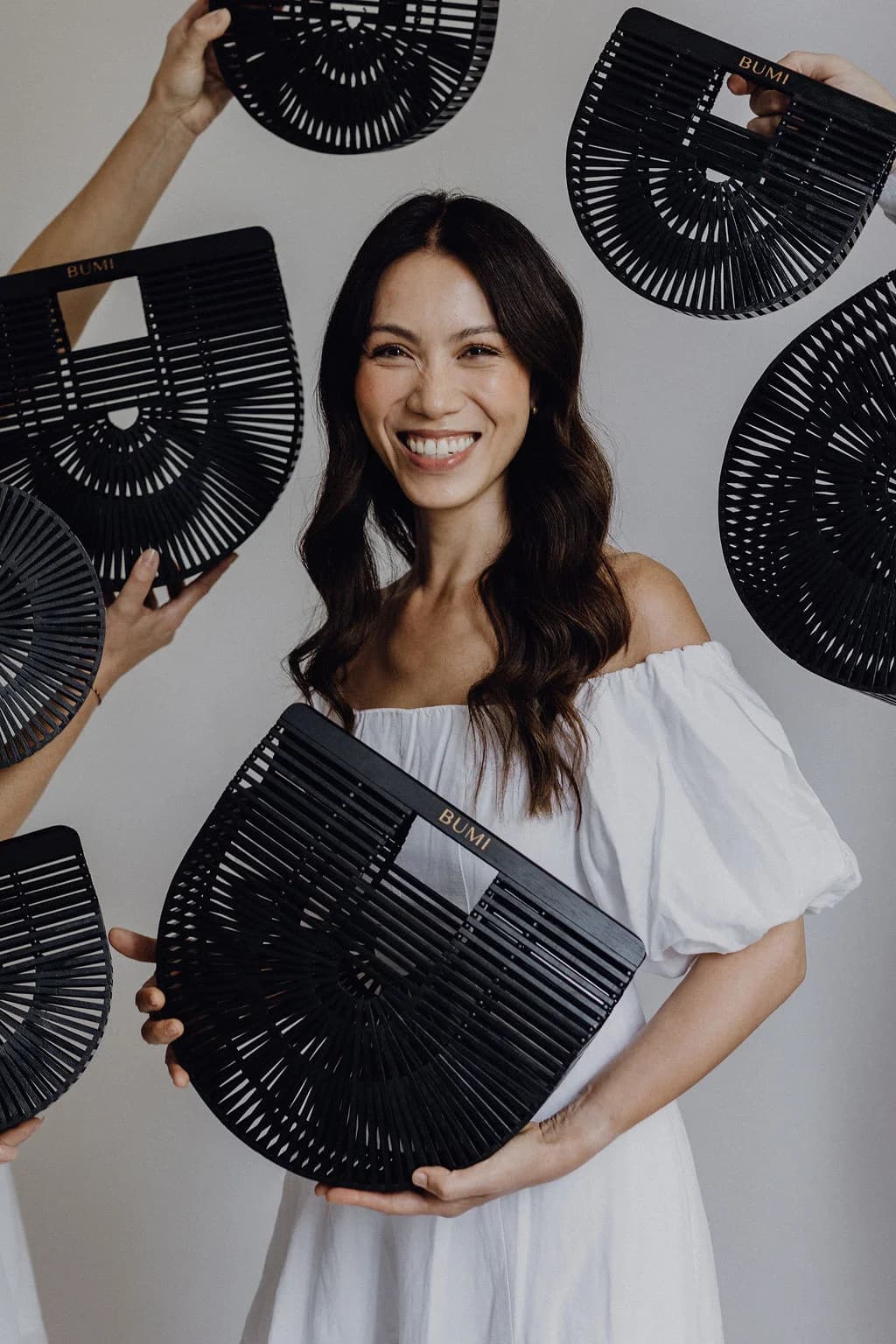 Kundin hält BUMI Tasche und lächelt – echtes Kundenfoto.