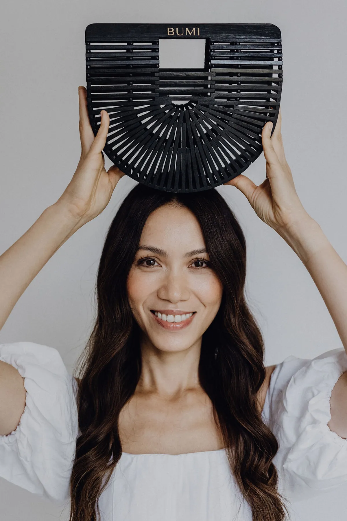 BUMI Bag Schwarz – Frau hält Tasche über den Kopf